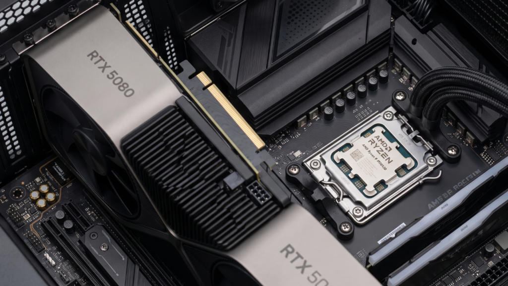 A close-up studio photograph focusing sharply on the massive RTX 5080 graphics card seated in the PCIe 5.0 slot next to the Ryzen 9 9950X3D CPU with a mounted AIO cooler on the X870 motherboard.